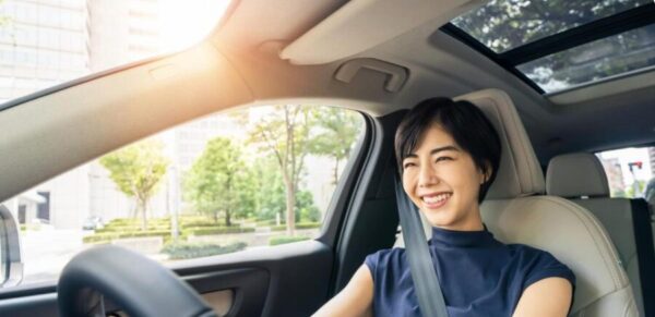 コンパクトカーを運転する日本人女性。トヨタのヤリスとアクアを比較する際に重視したい運転のしやすさをイメージ。