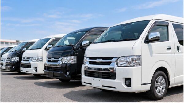中古車販売店に白や黒のトヨタハイエースが複数並ぶ様子。中古ハイエースの価格相場や車両選びを比較するイメージ。